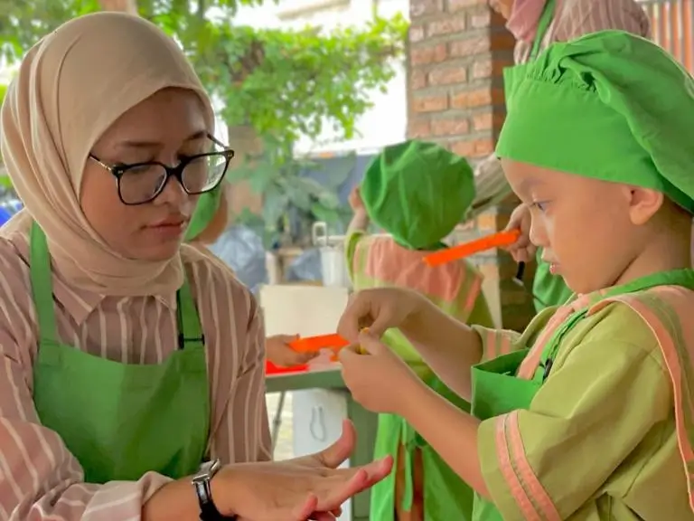 Anak-anak sedang memasak bersama guru